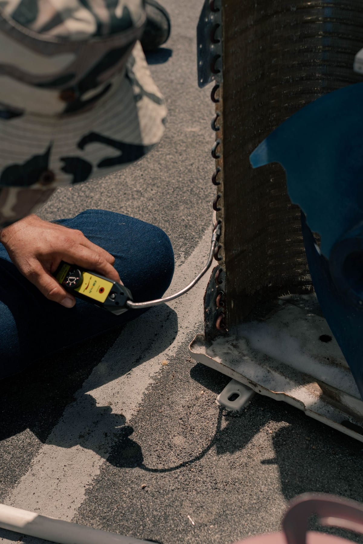 Technician checking an AC coil for refrigerant leaks